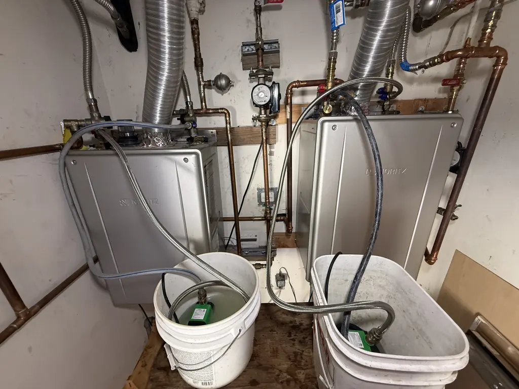 Both tankless heaters flushing, each with its own pump and bucket