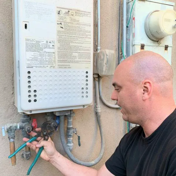 Tankless water heater — gas valves and flex connections at the wall unit.