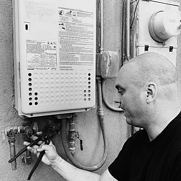 Tankless water heater — gas valves and flex connections at the wall unit.
